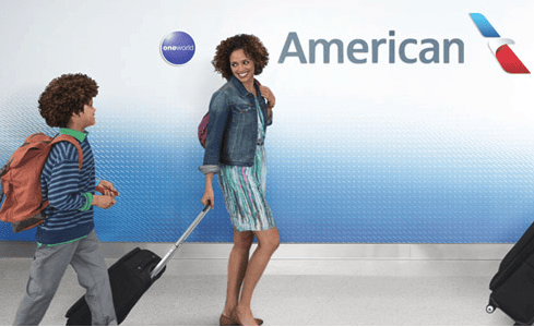 A traveler checking in at an American Airlines counter with luggage.