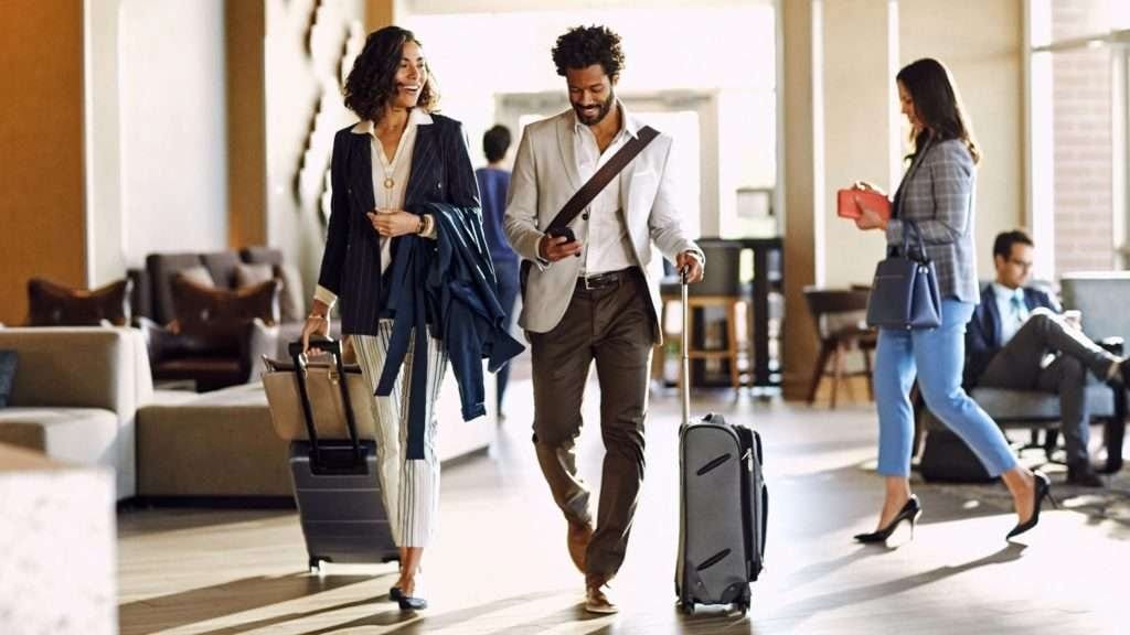 A well-dressed business traveler checking into a luxurious hotel lobby.