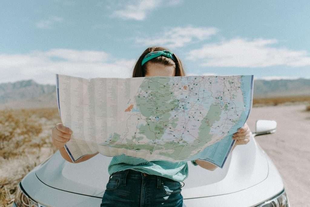 Road trip traveler navigating Solo traveler exploring the route with a detailed map in hand