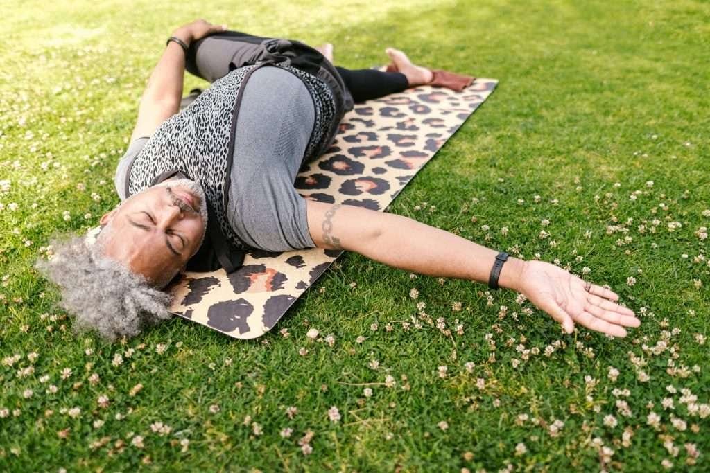 man laying on grass doing yoga