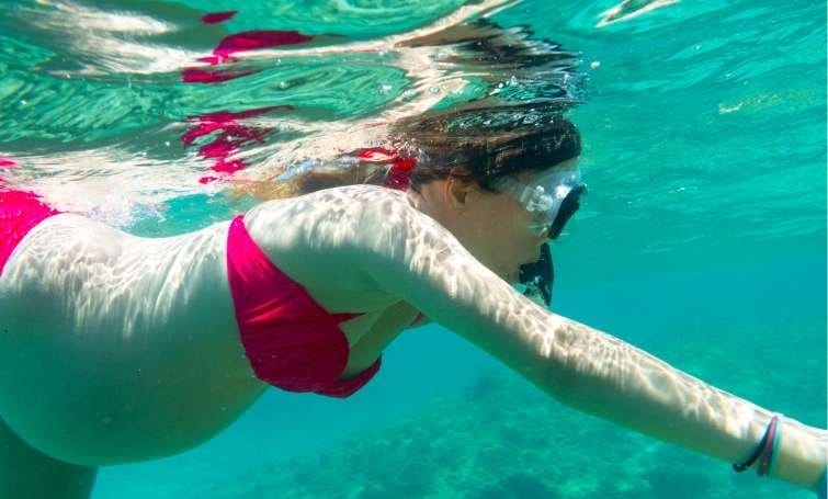 A woman snorkeling while pregnant