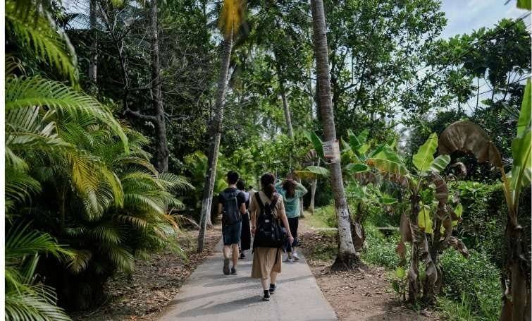 Diverse group of hikers using eco-friendly travel apps in sustainable forest.