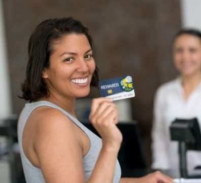 a woman in the airport counter showing reward card