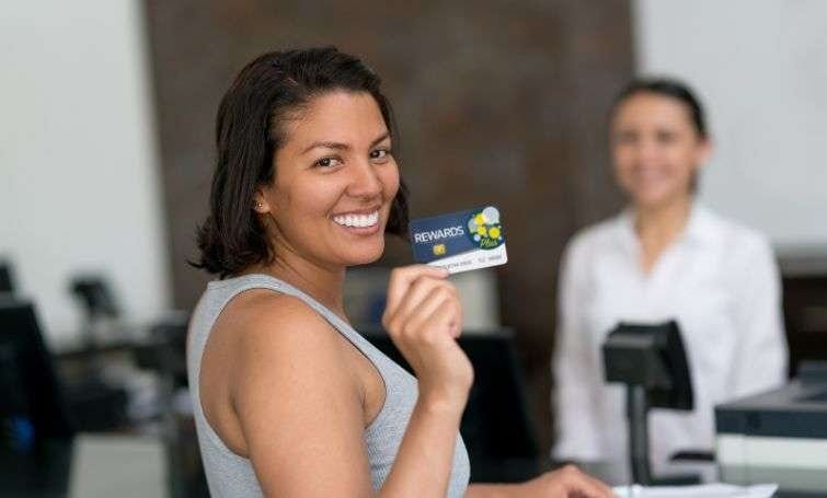 a woman in the airport counter showing reward card